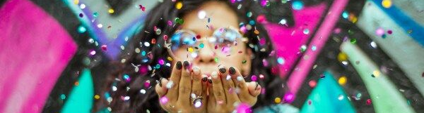 Ihminen puhaltaa käsistään glitteriä.